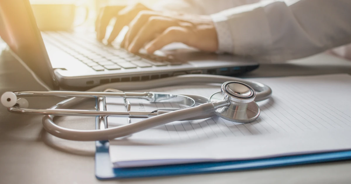 Stethoscope and medical notes beside a laptop, representing accessible communication and BSL interpreting in healthcare.